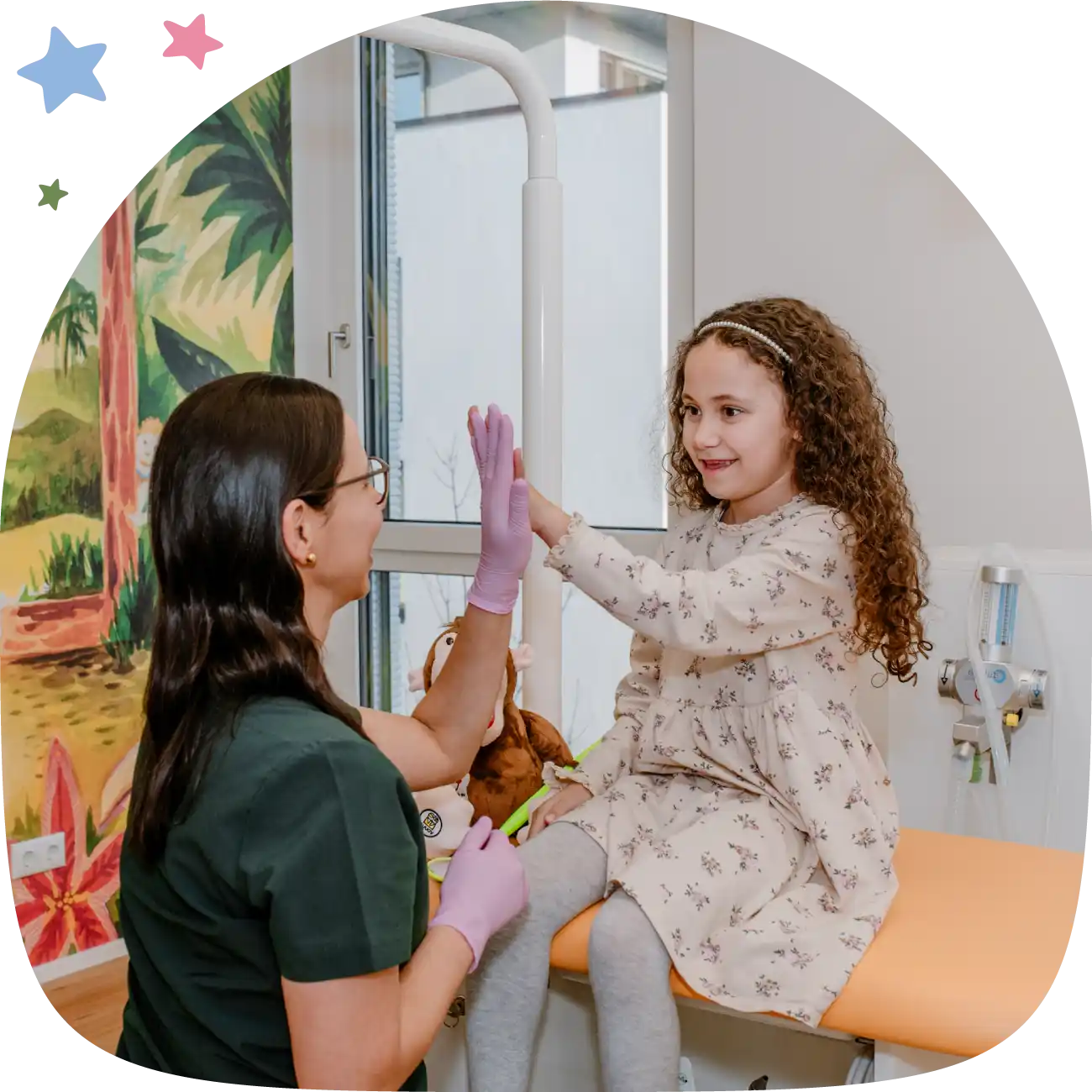 Margarita Ruiz-Bamberg und ein Kind geben sich High-Five im Behandlungszimmer
